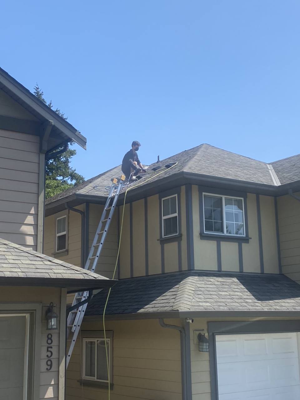 Employee accessing a residential rooftop by ladder for exterior service