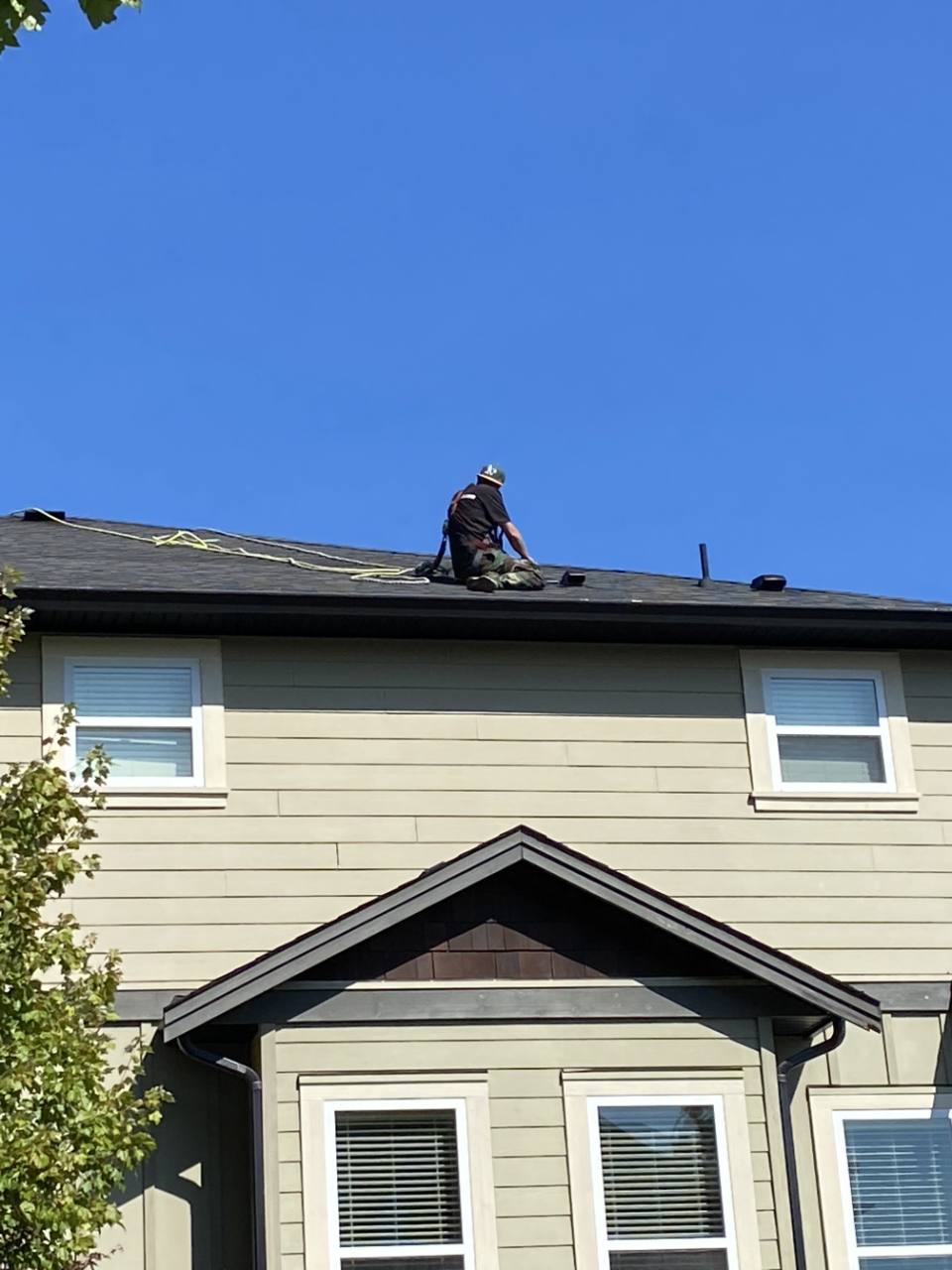 Employee servicing rooftop vents on a residential building
