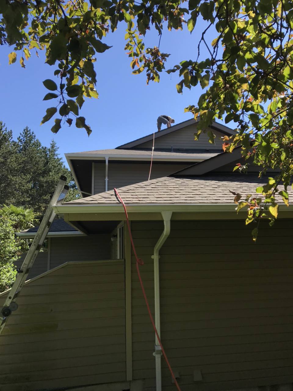 Employee performing rooftop service on a townhouse